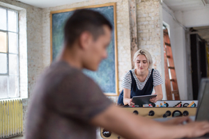 Young adult female using digital tablet in a creative office