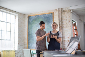 Young adults using digital tablet in a creative office