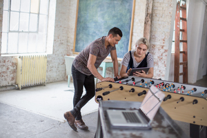 Young adults using digital tablet in a creative office