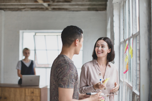 Young adults brainstorming in a creative office with adhesive notes