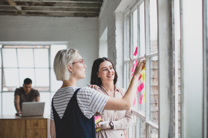 Young adults brainstorming in a creative office with adhesive notes