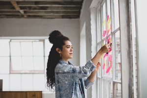 Young adult female brainstorming in a creative office with adhesive notes