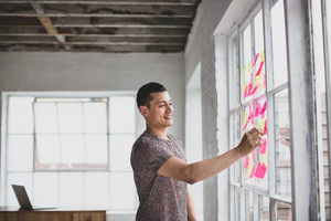 Young adult male brainstorming in a creative office with adhesive notes