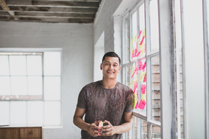 Portrait of young adult male brainstorming in a creative office with adhesive notes