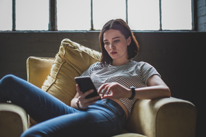 Millennial using smartphone in a loft apartment