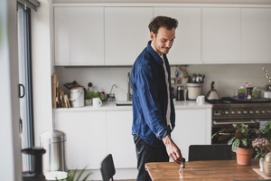 Adult male picking up keys from kitchen table
