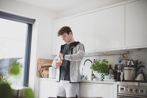 Young adult male drinking orange juice before after a run