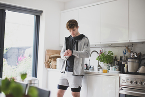 Young adult male setting his activity tracker before a run
