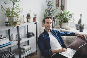 Portrait of adult male working from home in living room