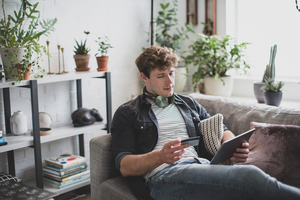 Young adult male shopping online using a digital tablet