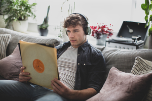 Young adult male looking at vinyl record