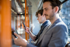 Commuter using smartphone on train