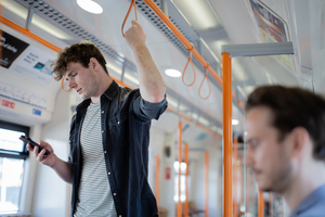 Commuter using smartphone on train
