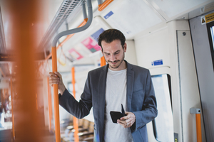 Commuter using smartphone on train