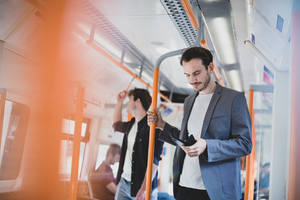 Commuter using smartphone on train