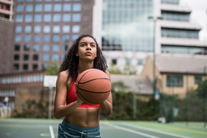 Young adult female basketball player about to shoot a hoop 