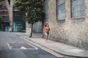 Young adult female running in urban city