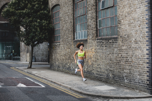Young adult female running in urban city