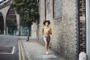 Young adult female running in urban city