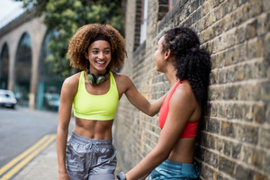 Young adult females taking a break on a run in urban city