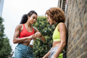 Young adult females taking a break on a run in urban city