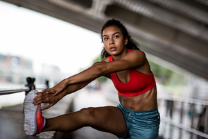Young adult female stretching before a run