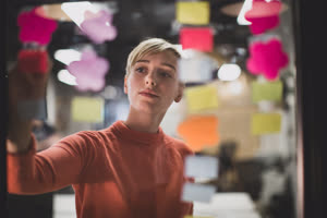 Young adult female brainstorming ideas at night in an office