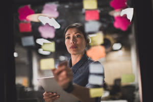 Adult female brainstorming ideas at night in an office