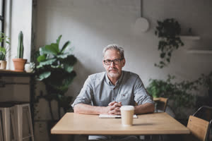 Portrait of mature businessman working in a cafe