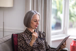 Mature adult female reading an ebook on a digital tablet
