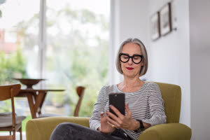 Mature adult female using a smartphone at home