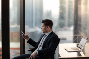 Businessman using smartphone in office skyscraper