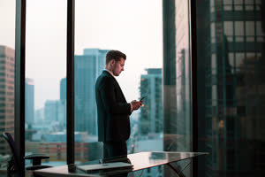 Businessman using smartphone in skyscraper office