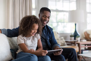 African American father and daughter using digital tablet together