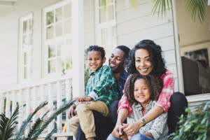 Portrait of African American family sitting outside home