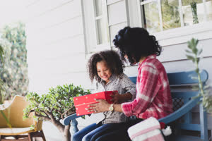 African American mother giving daughter a christmas gift
