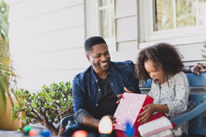 African American father giving daughter a christmas gift
