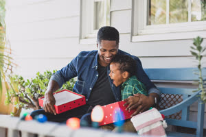 African American father giving son a christmas gift
