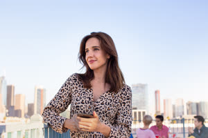 Young adult female looking out across city at a rooftop party