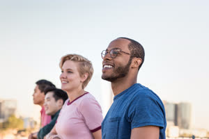 Group of friends looking out at city skyline view on a rooftop