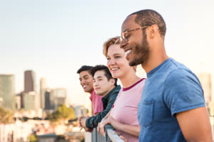 Group of friends looking out at city skyline view on a rooftop