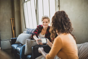 Young adult friends looking at a smartphone together 