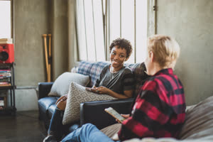 Young adult friends socialising whilst on their smartphones