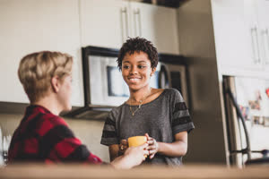 Female couple having coffee together in loft apartment