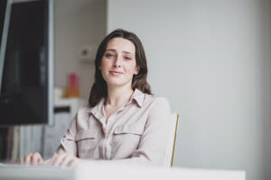 Portrait of a female business executive working in an office on a desktop computer