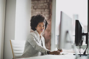 Portrait of a female african american business executive working in an office on a desktop computer