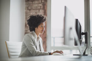 Female african american business executive working in an office on a desktop computer