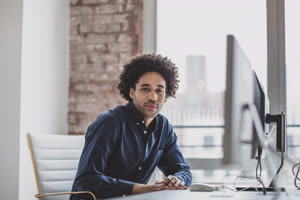 Portrait of a male african american business executive working in an office on a desktop computer