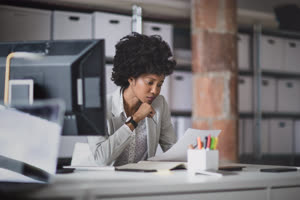Female african american business executive working in an office looking at paperwork