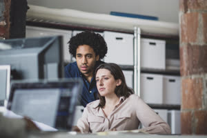 Coworkers looking at a desktop computer together